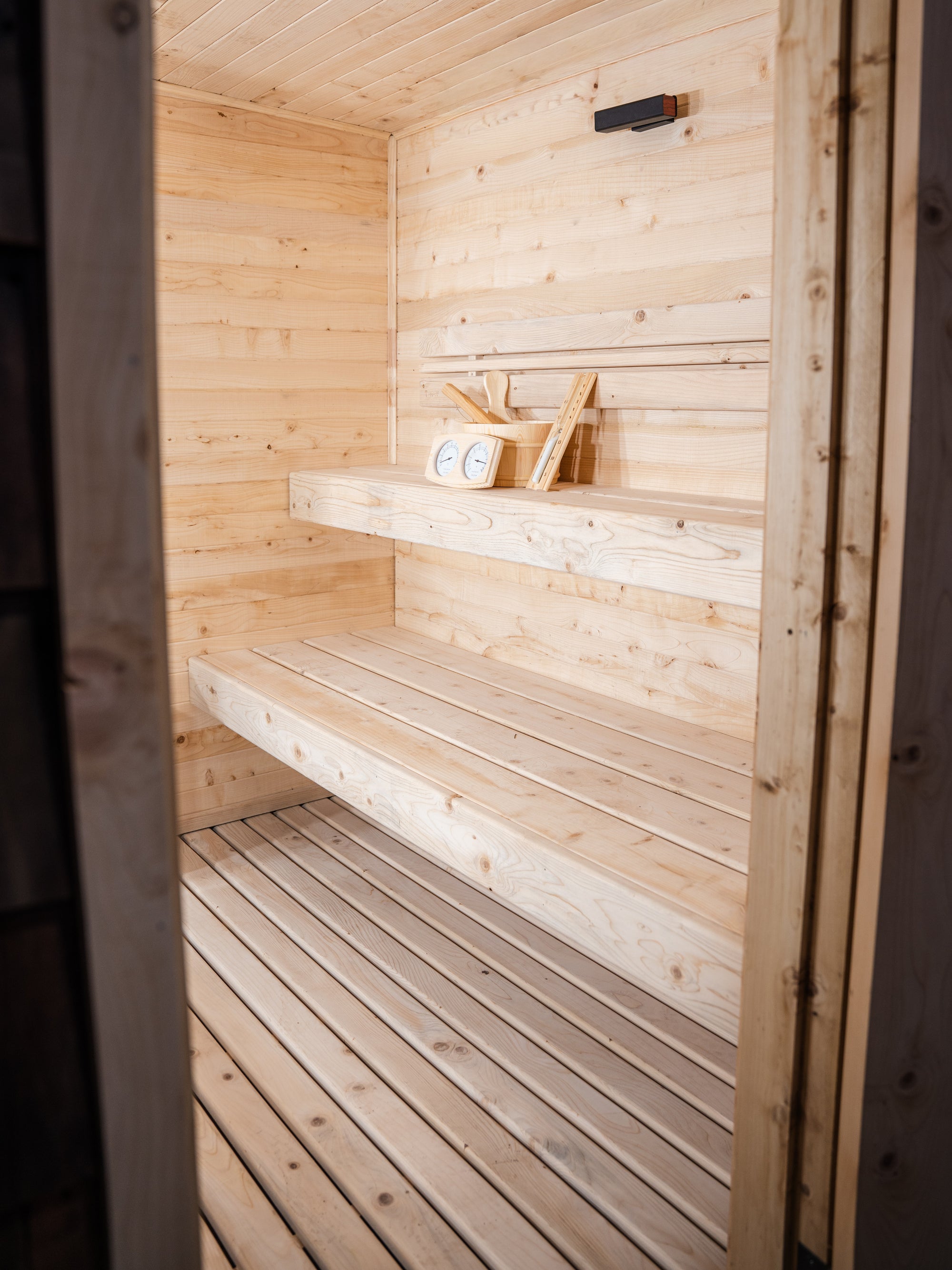 Interior de sauna exterior para 4 personas con bancas de ciprés